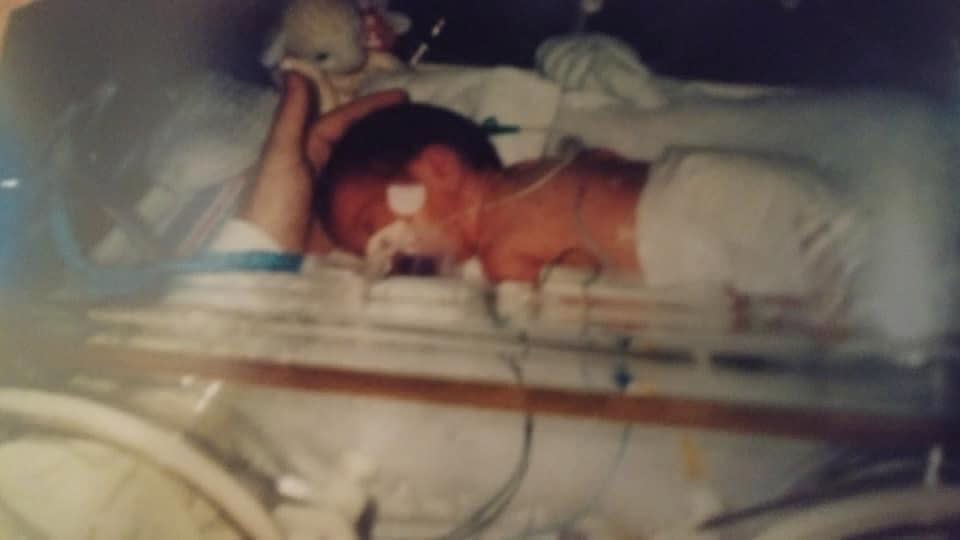 newborn baby in hospital bed in NICU